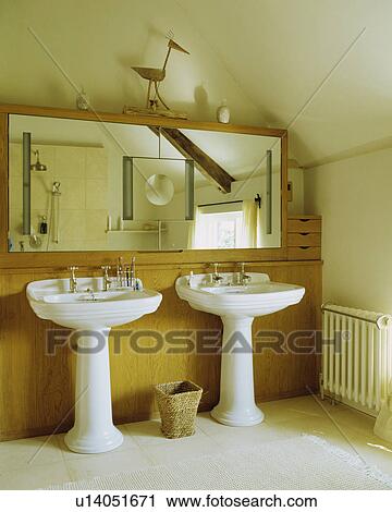 Twin white basins in a traditional bathroom under the eaves of an attic conversion View Large Photo Image Stock Image - Twin white basins in a traditional bathroom under the eaves of an attic conversion . Fotosearch