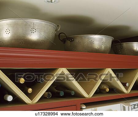 Unusual bottle storage detail in wooden kitchen. View Large Photo Image Picture - Unusual bottle storage detail in wooden kitchen.. Fotosearch