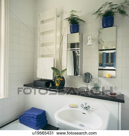 Vertical White Radiator And Mirrored Cabinets Above Built In Basin In Modern White Bathroom Stock Image U19565431 Fotosearch