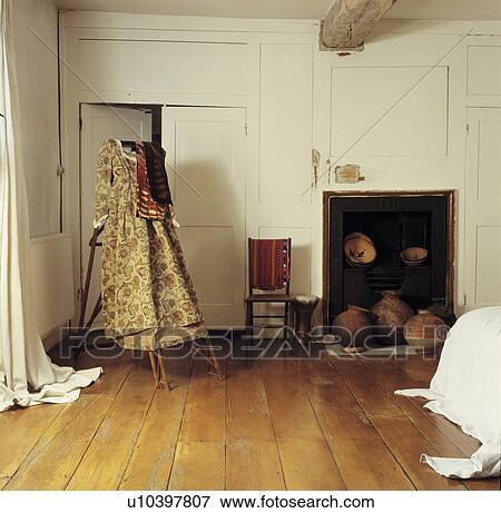 Victorian Gown On Stand In Cream Country Bedroom With Fireplace