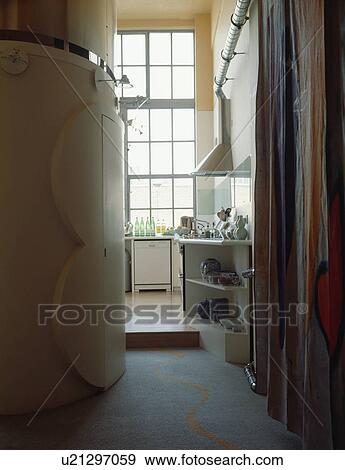 Stock Photo - View from hall with curved wall to modern kitchen in loft conversion. Fotosearch
