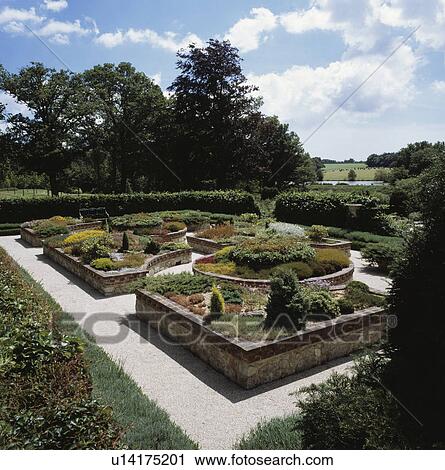 Stock Image - Walled raised beds in formal parterre garden in summer. Fotosearch