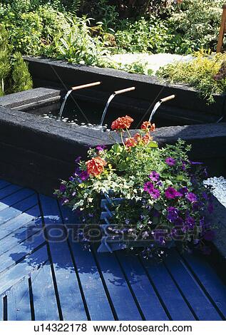 Water jets and raised pond with painted blue decking in summer garden View Large Photo Image Stock Photo - Water jets and raised pond with painted blue decking in summer garden. Fotosearch