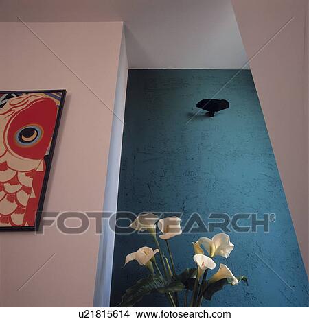 Picture - White Arum lilies in front of rough turquoise wall in modern white hall. Fotosearch