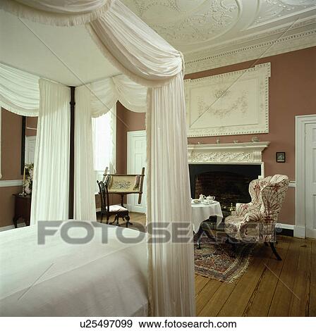 White Drapes And Linen On Fourposter Bed In Country Bedroom