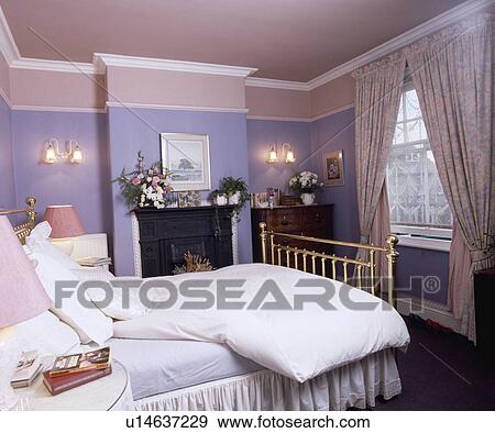 White Duvet And Pillows On Brass Bed In Mauve Bedroom With Pink Ceiling And Floral Curtains Stock Photo