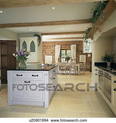 White island unit in openplan kitchen and dining room with limestone floor View Large Photo Image Picture - White island unit in openplan kitchen and dining room with limestone floor. Fotosearch