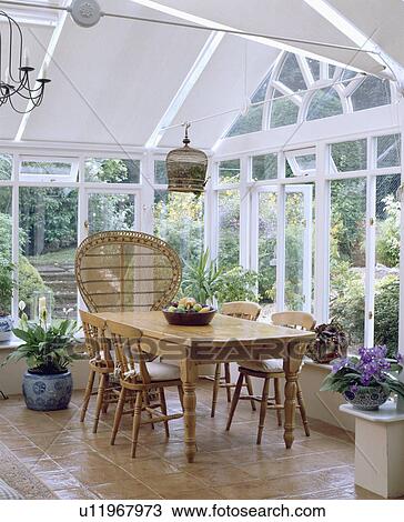 Stock Image - White painted wooden conservatory with plain white roller blinds.. Fotosearch