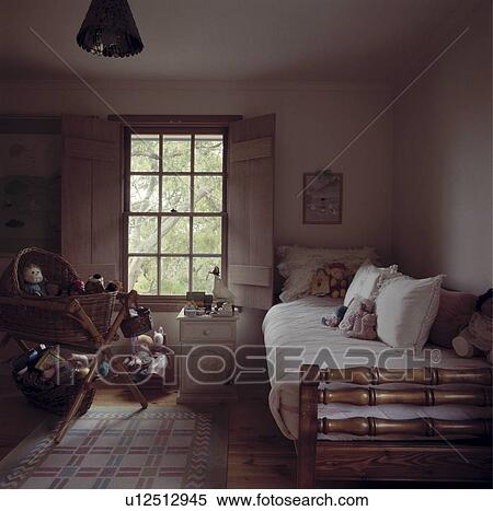 White pillows and quilts on wooden single bed in child's bedroom with baskets of toys below sash window View Large Photo Image Stock Photography - White pillows and quilts on wooden single bed in child's bedroom with baskets of toys below sash window. Fotosearch