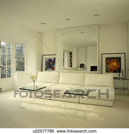 White sofa and perspex tables below large mirror in modern uncluttered living room View Large Photo Image Stock Photography - White sofa and perspex tables below large mirror in modern uncluttered living room. Fotosearch
