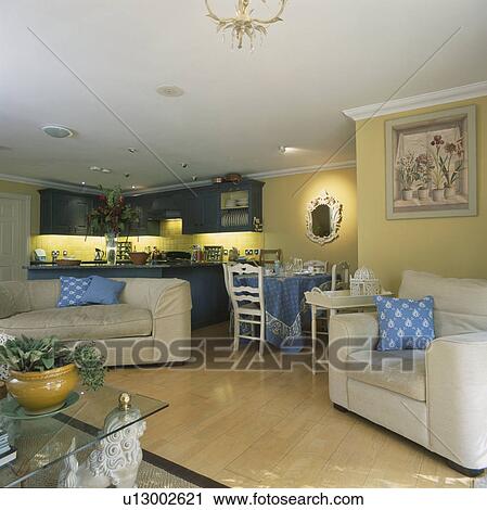 White sofas in yellow apartment kitchen dining room with underlit cupboards and wooden flooring View Large Photo Image Stock Image - White sofas in yellow apartment kitchen dining room with underlit cupboards and wooden flooring . Fotosearch