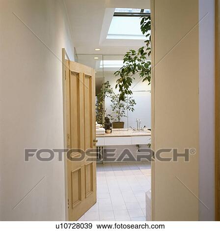 White tiled floor in modern white loft bathroom with pale wood door View Large Photo Image Stock Photo - White tiled floor in modern white loft bathroom with pale wood door. Fotosearch