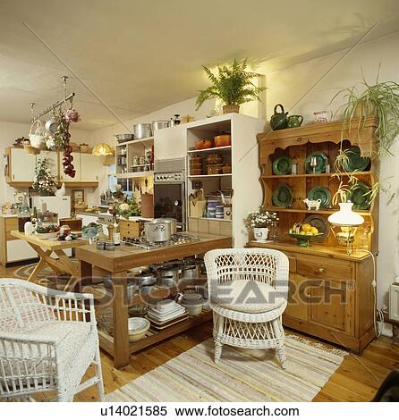 White wicker chairs and pine dresser with lighted lamp in large traditional kitchen View Large Photo Image Stock Photography - White wicker chairs and pine dresser with lighted lamp in large traditional kitchen. Fotosearch