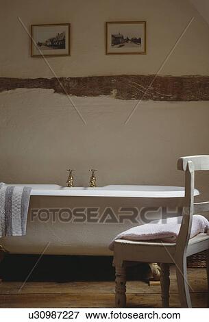 White wooden chair and white rolltop bath in country bathroom View Large Photo Image Stock Photo - White wooden chair and white rolltop bath in country bathroom. Fotosearch