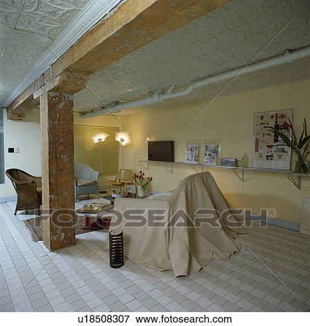 White+grey floor tiles in loft conversion living room with cream loosecover on sofa View Large Photo Image Stock Photo - White+grey floor tiles in loft conversion living room with cream loosecover on sofa. Fotosearch