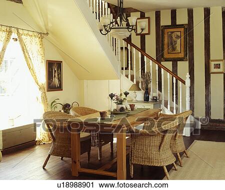 Wicker armchairs and rectangular wooden table in cream hall dining room with beamed wall View Large Photo Image Stock Image - Wicker armchairs and rectangular wooden table in cream hall dining room with beamed wall. Fotosearch