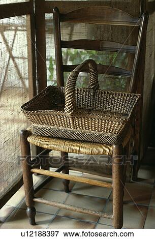 Stock Photo - Wicker basket on old rush-seated chair. Fotosearch