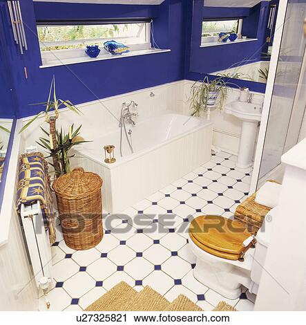 Wicker Laundry Basket Beside Bath Below Narrow Window In Blue Wicker Laundry Basket Beside Bath Below