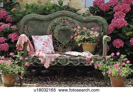 Stock Photography - Wicker sofa and pink hydrangeas. Fotosearch