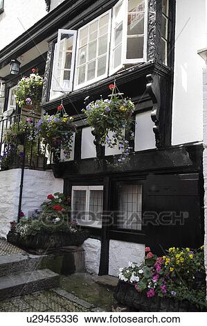 Stock Photograph - Windows with carved frames on traditional white timbered cottage. Fotosearch