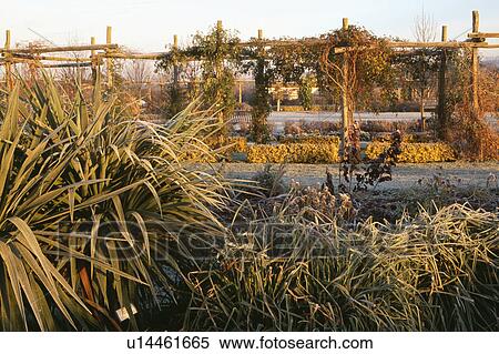 Stock Photography - Wooden arch and pergola in country garden in winter. Fotosearch