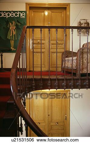 Stock Photograph - Wooden bannisters on staircase and landing with picture beside double dwooden doors. Fotosearch