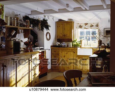 Wooden fitted cupboards in white cottage kitchen with white beamed ceiling View Large Photo Image Picture - Wooden fitted cupboards in white cottage kitchen with white beamed ceiling. Fotosearch