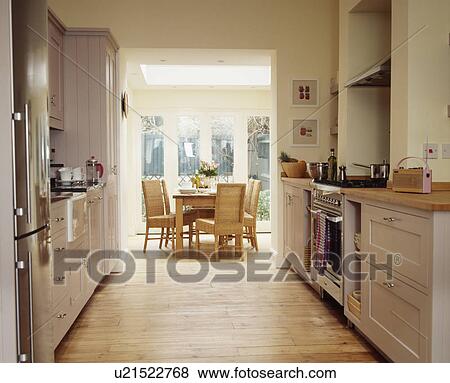 Stock Photo - Wooden flooring in modern cream kitchen dining room extension. Fotosearch