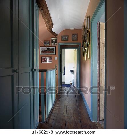 Stock Photo - Wooden flooring in narrow landing with pastel pink walls and pastel turquoise paintwork. Fotosearch