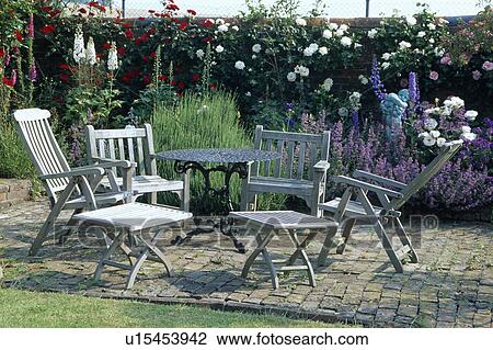 Wooden furniture on patio in country garden in summer View Large Photo Image Stock Image - Wooden furniture on patio in country garden in summer. Fotosearch