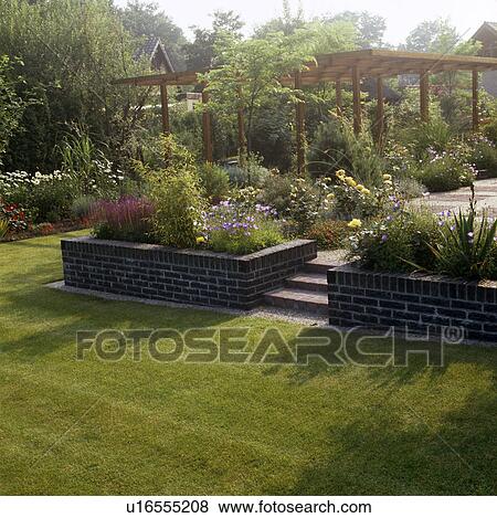 Stock Photo -  Wooden pergola in country garden in summer. Fotosearch