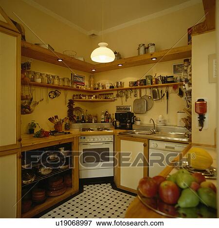 Wooden shelves above oven in corner of small economy style kitchen View Large Photo Image Stock Photo - Wooden shelves above oven in corner of small economy style kitchen. Fotosearch
