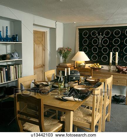 Wooden table and chairs with rush seats in dining room with large picture over sideboard View Large Photo Image Stock Image - Wooden table and chairs with rush seats in dining room with large picture over sideboard. Fotosearch