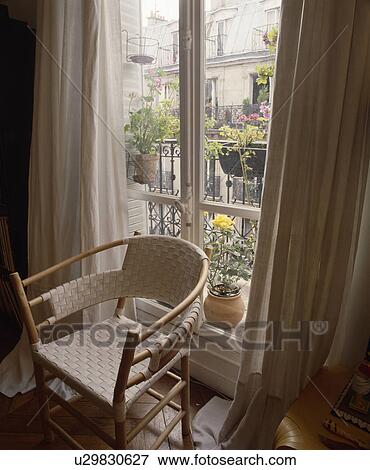 Woven chair and cream curtains View Large Photo Image Stock Photo - Woven chair and cream curtains. Fotosearch
