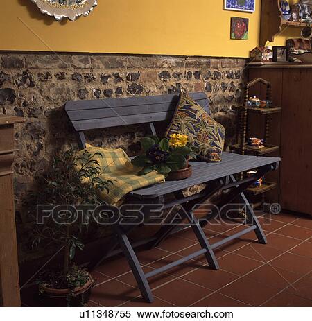Yellow checked rug on painted blue wooden bench against exposed stone wall in yellow room View Large Photo Image Stock Photography - Yellow checked rug on painted blue wooden bench against exposed stone wall in yellow room. Fotosearch