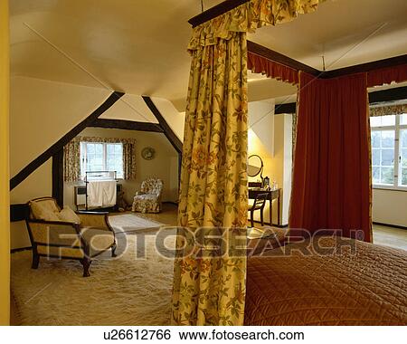 Yellow floral drapes on four-poster bed in cream attic bedroom with cream fur rug View Large Photo Image Stock Photograph - Yellow floral drapes on four-poster bed in cream attic bedroom with cream fur rug. Fotosearch