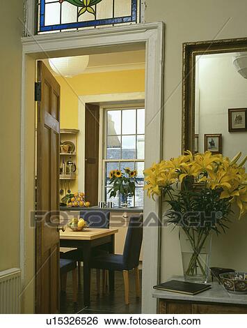 Yellow lilies in vase on shelf beside open door with view of yellow kitchen View Large Photo Image Stock Photograph - Yellow lilies in vase on shelf beside open door with view of yellow kitchen. Fotosearch
