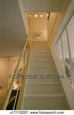 Yellow metal bannisters on white staircase with ceiling spotlights View Large Photo Image Stock Photo - Yellow metal bannisters on white staircase with ceiling spotlights. Fotosearch