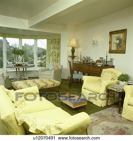 Stock Image - Yellow sofa and armchairs in traditional town living room. Fotosearch