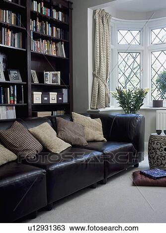 黒い革 ソファー で クリーム クッション の前 黒 本棚 中に 現代 Livingroom ストックイメージ U Fotosearch