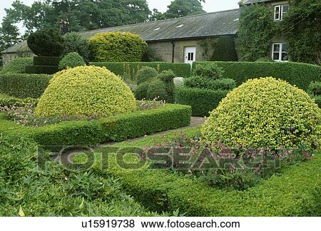 Stock Photo - &#13; &#10; Clipped shrubs in large garden of country house in summer. Fotosearch