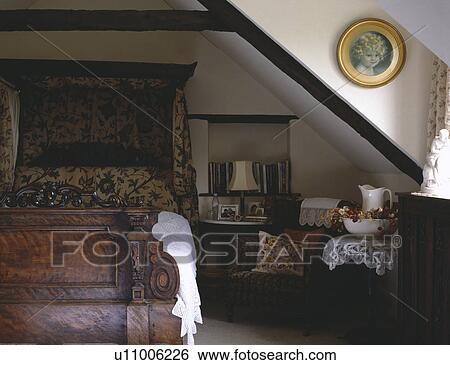 19th-century carved half-tester bed with antique crewelwork hangings in attic country bedroom View Large Photo Image Stock Photograph - 19th-century carved half-tester bed with antique crewelwork hangings in attic country bedroom. Fotosearch