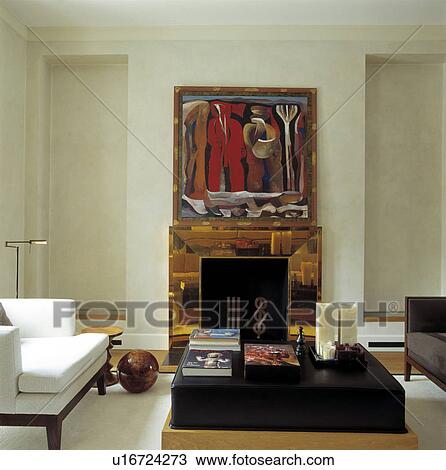 Stock Image - Abstract painting above glass mantelpiece in modern living room. Fotosearch
