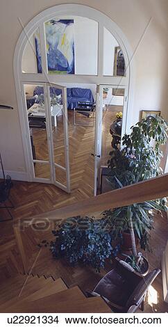 Aerial view of houseplants and parquet floor in hall with arched glass doors into living room View Large Photo Image Picture - Aerial view of houseplants and parquet floor in hall with arched glass doors into living room. Fotosearch