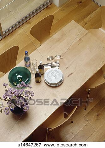 Aerial view of plates and cutlery on modern wooden table in dining room with wooden flooring View Large Photo Image Stock Photo - Aerial view of plates and cutlery on modern wooden table in dining room with wooden flooring. Fotosearch