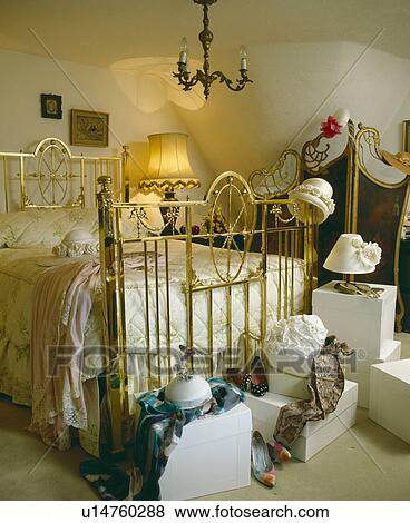 Antique brass bed in country cottage bedroom with collection of hats and hatboxes View Large Photo Image Stock Photo - Antique brass bed in country cottage bedroom with collection of hats and hatboxes. Fotosearch