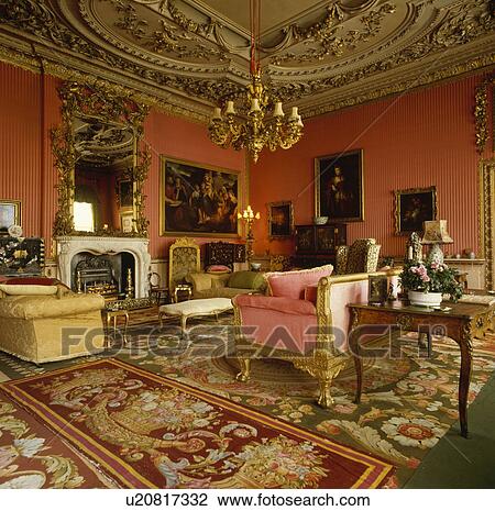 Stock Image - Antique carpets in red drawing room with ornate ceiling. Fotosearch