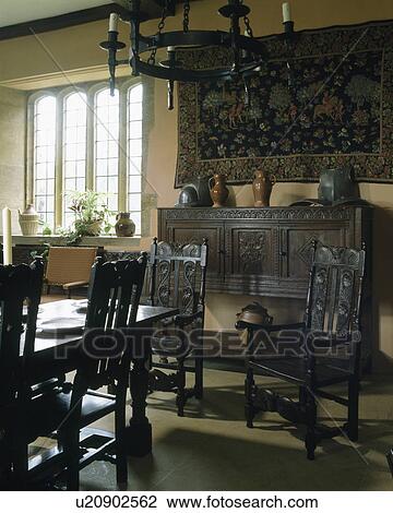 Antique carved wooden chair and sideboard in country diningroom with wooden ceiling candelabra View Large Photo Image Stock Image - Antique carved wooden chair and sideboard in country diningroom with wooden ceiling candelabra. Fotosearch