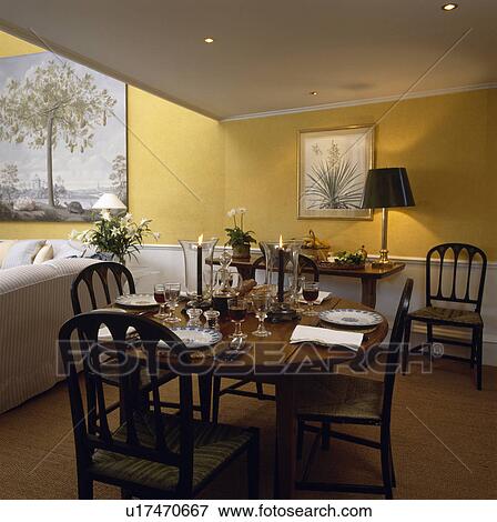 Stock Photo - Antique circular table and chairs in yellow eighties dining room with sisal carpet. Fotosearch