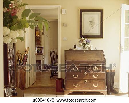 Antique desk beside open dining room door in cream cottage hall View Large Photo Image Stock Photo - Antique desk beside open dining room door in cream cottage hall. Fotosearch